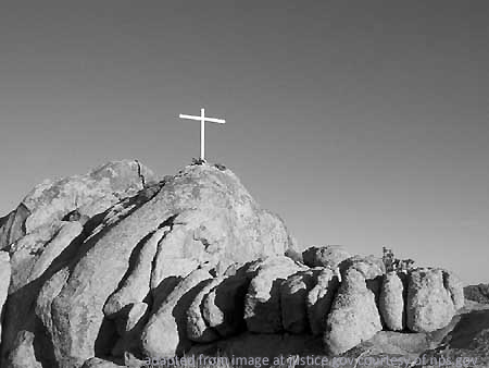 Cross in Desert Atop Rocks, adapted from image at justice.gov