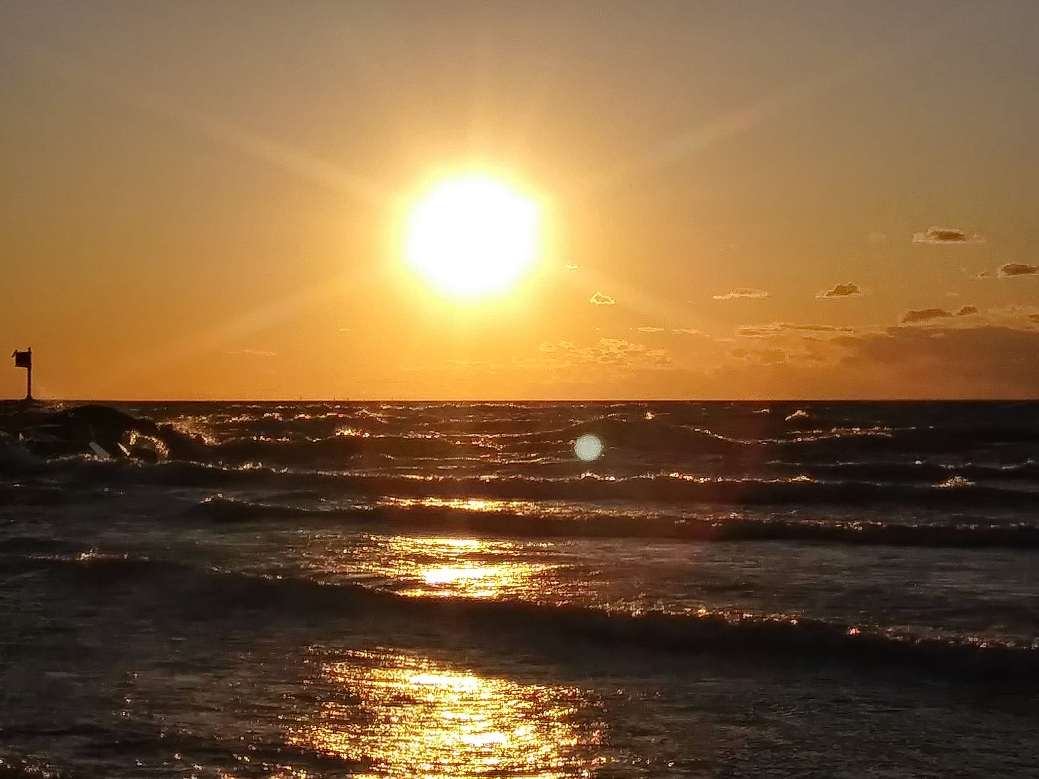 Golden Sun Low on Horizon Over Water with Waves and Ripples